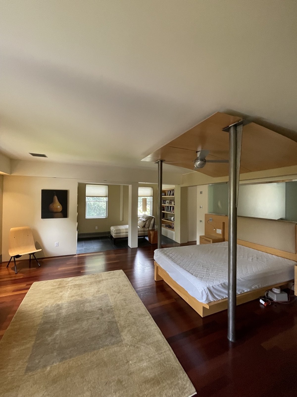 Master bedroom with canopy bed, built-in shelving and warm paint colors