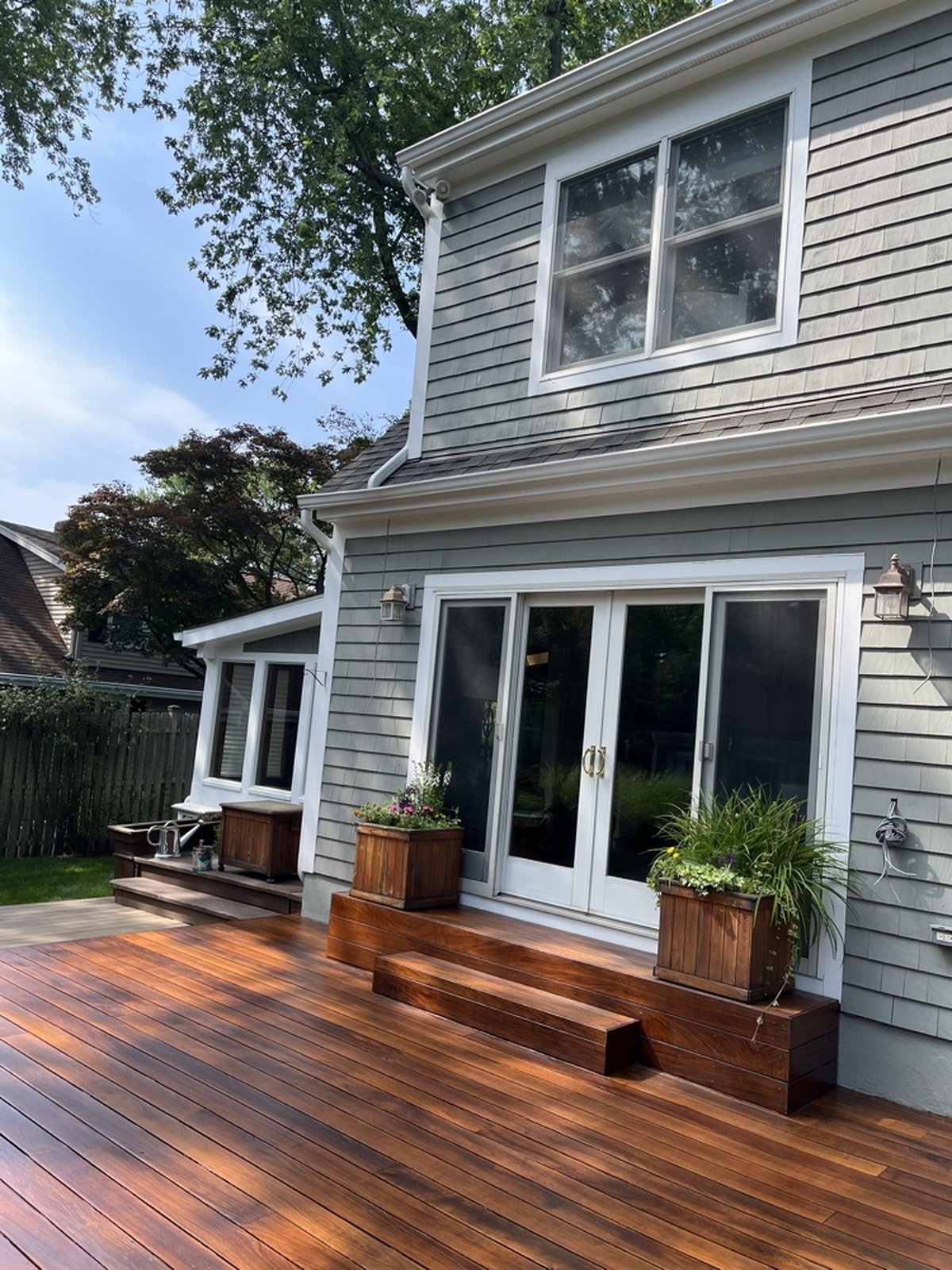 Premium deck staining with warm tones creating beautiful transition between home and outdoor space